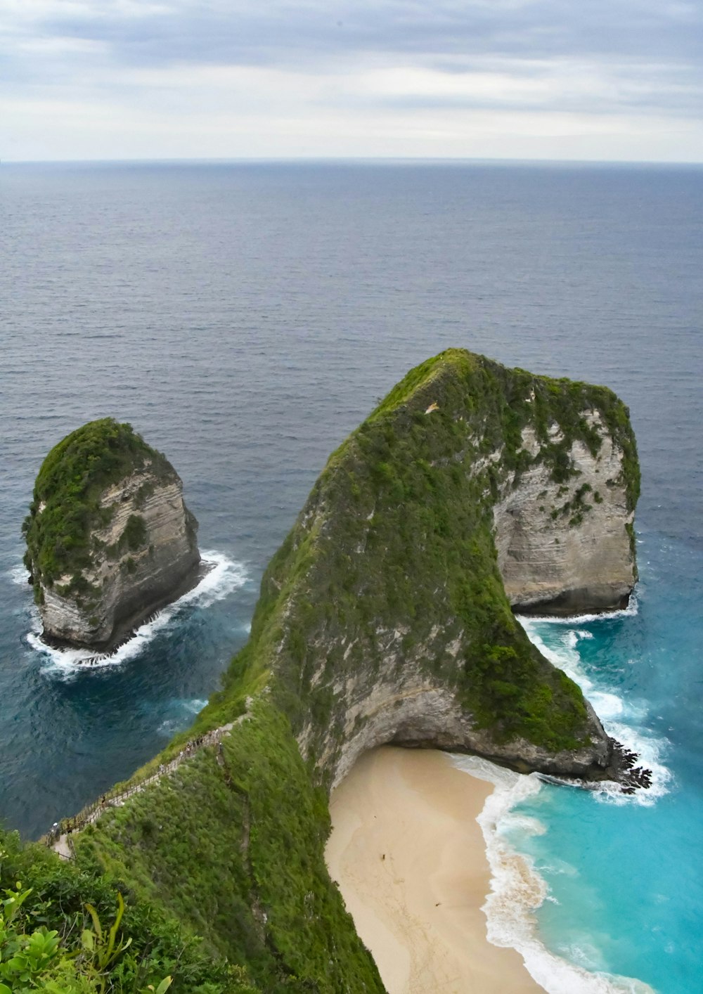 green and brown rock formation on sea during daytime