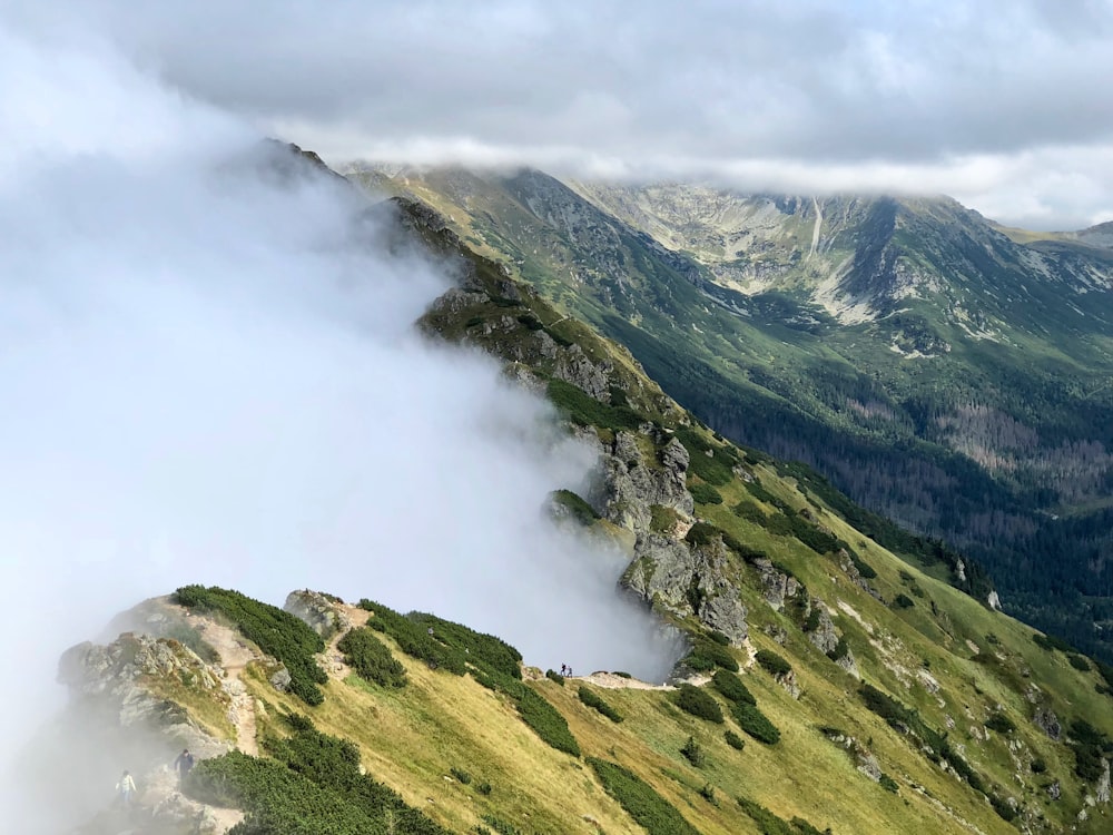 Montañas verdes bajo nubes blancas durante el día