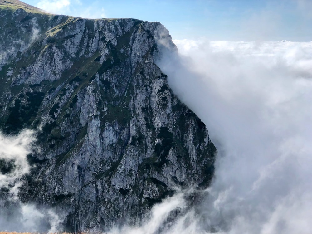 gray rocky mountain under white clouds during daytime