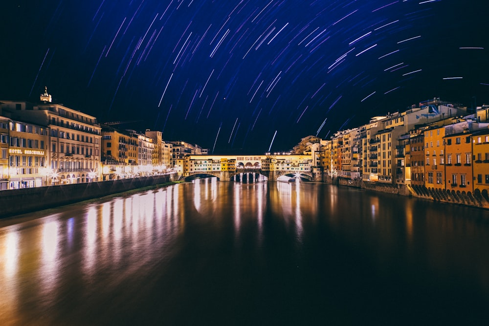 body of water near city buildings during night time