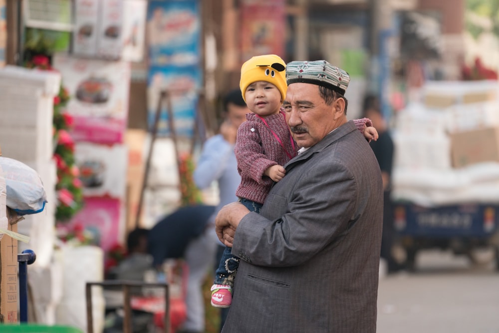 man in black coat and yellow knit cap standing near people during daytime