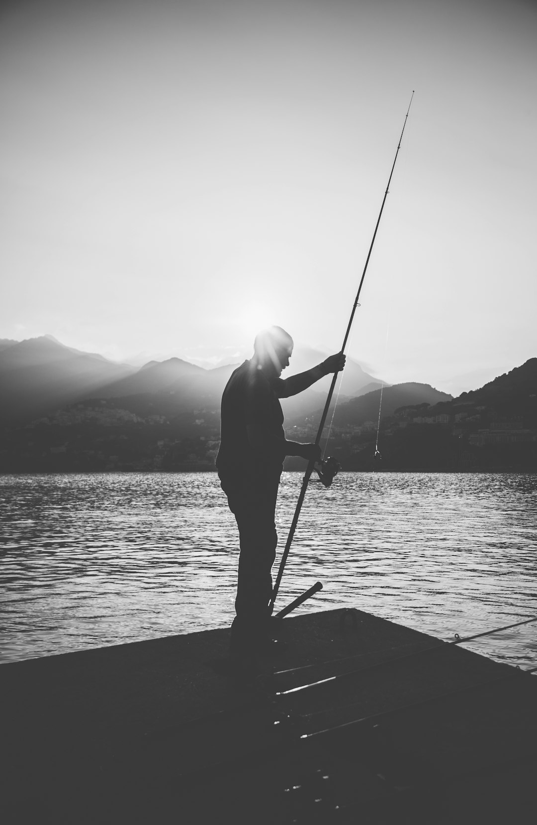 man in black jacket and pants fishing on sea during daytime