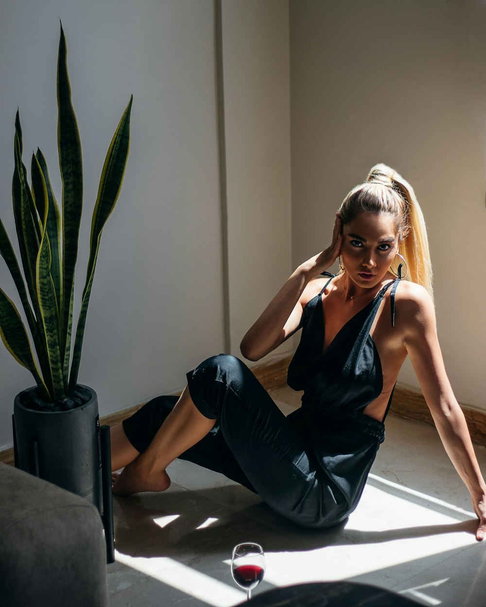 woman in black tank top and black leather pants sitting on floor