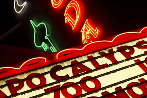A vibrant storefront sign glowing at dusk, showcasing bold red and white colors.