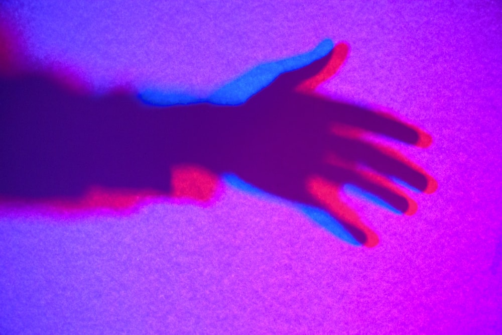 persons left hand with pink background