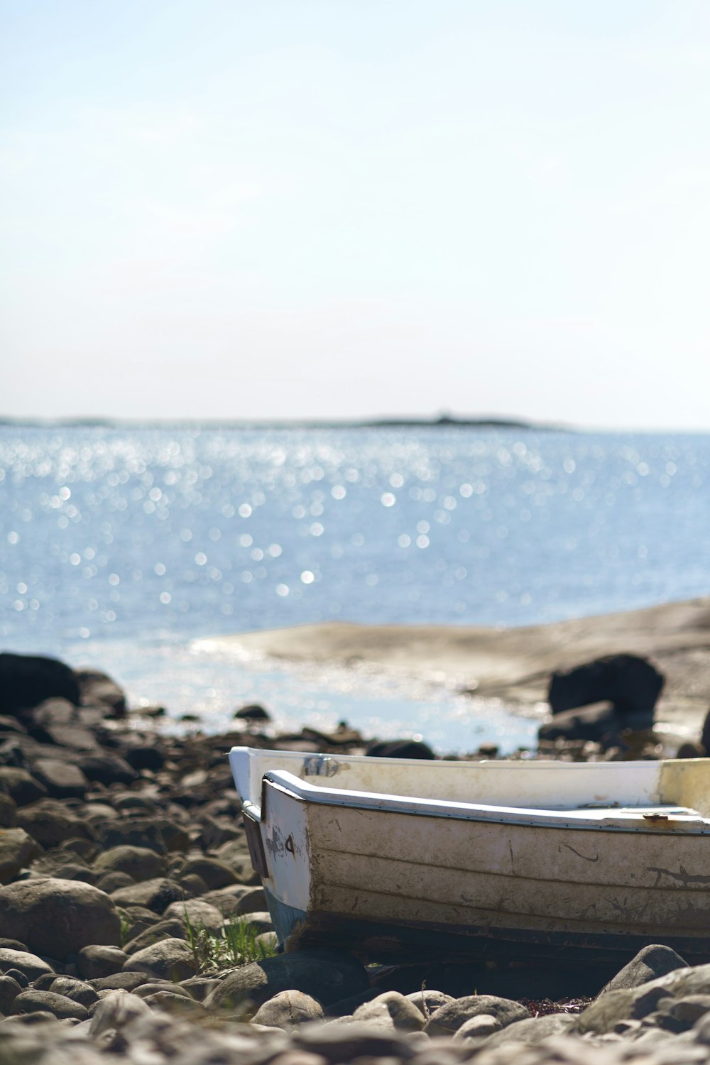 white and brown wooden boat on beach shore during daytime