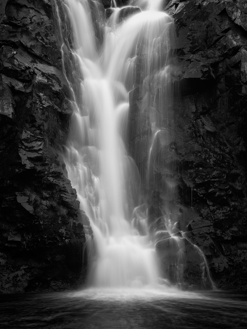 Foto en escala de grises de cascadas durante el día