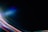 A dark canvas is intersected by vibrant streaks of colored light, including reds, blues, greens, and purples, creating a dynamic and futuristic atmosphere. The light patterns appear to move across the image, giving a sense of motion.