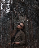 woman in brown coat standing near brown tree during daytime