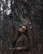 woman in brown coat standing near brown tree during daytime