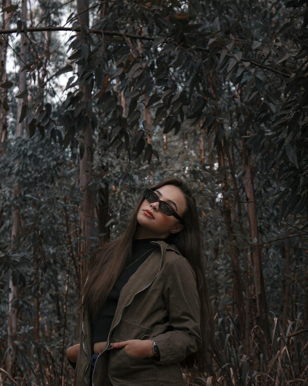woman in brown coat standing near brown tree during daytime