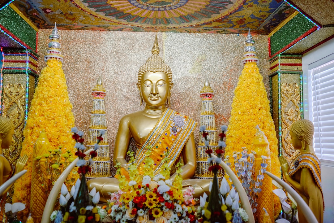 gold buddha statue surrounded by flowers