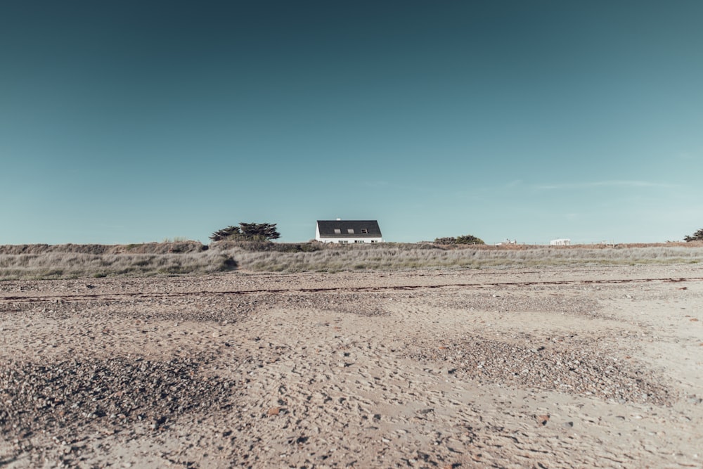 black house on brown field under blue sky during daytime