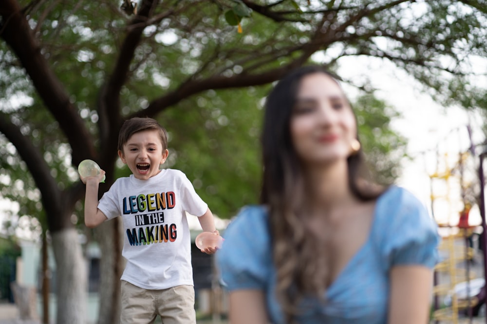 woman in blue crew neck t-shirt carrying girl in white long sleeve shirt