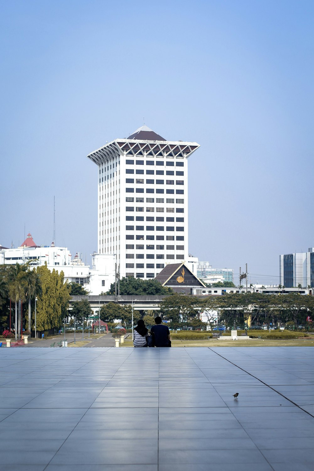 two people sitting on a bench in front of a building