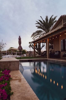 woman in brown dress standing near swimming pool during daytime