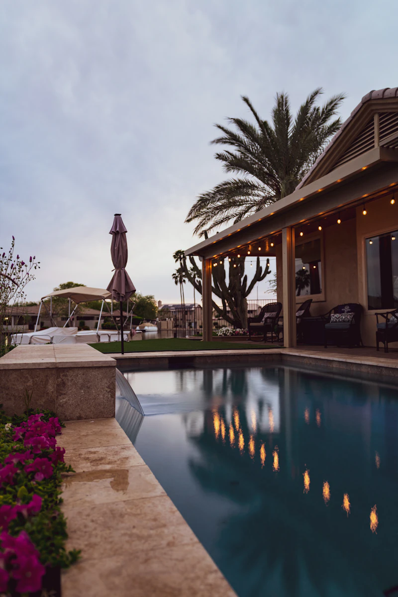 Beautifully maintained backyard pool glowing at dusk