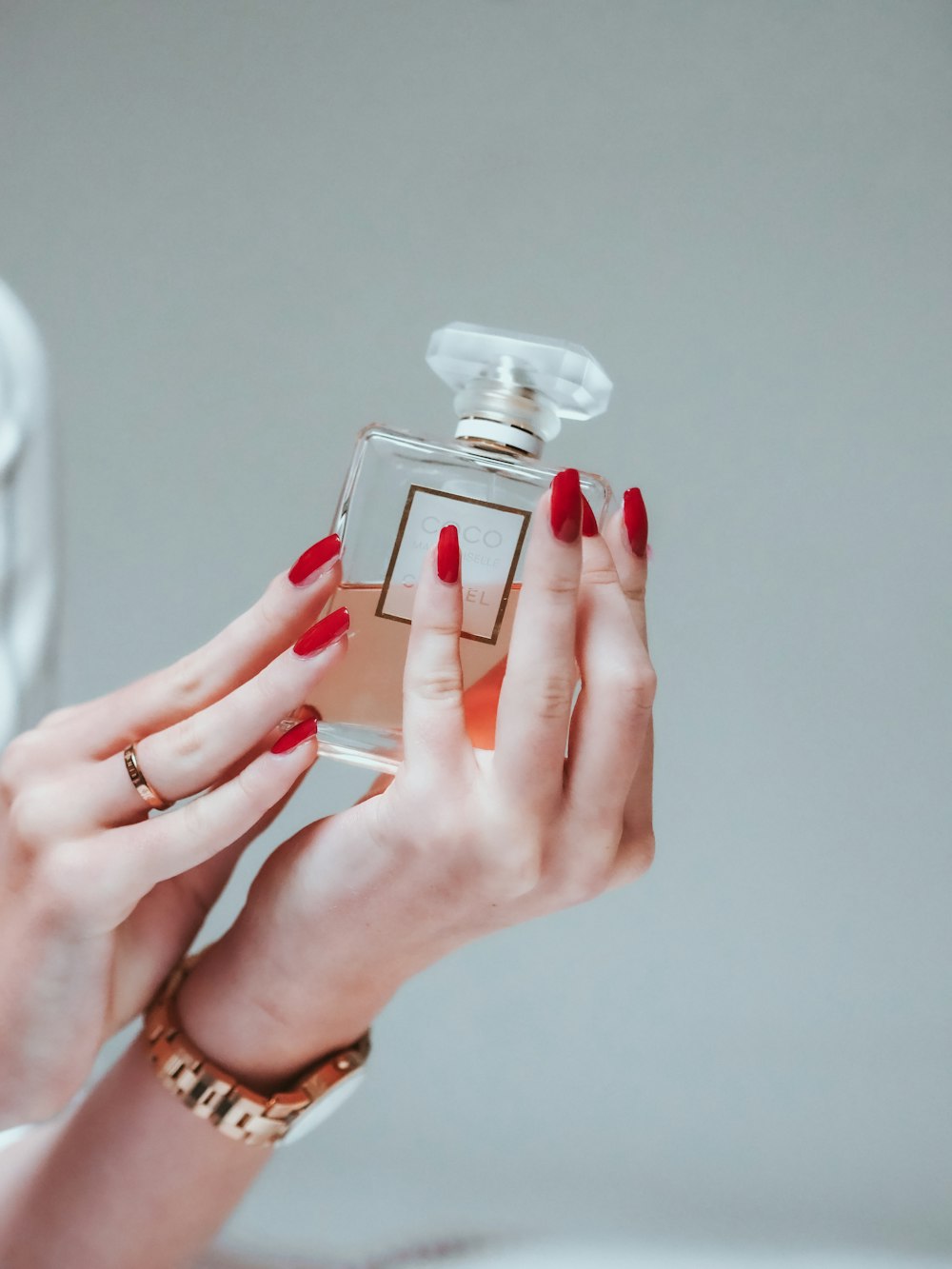 person holding clear glass bottle