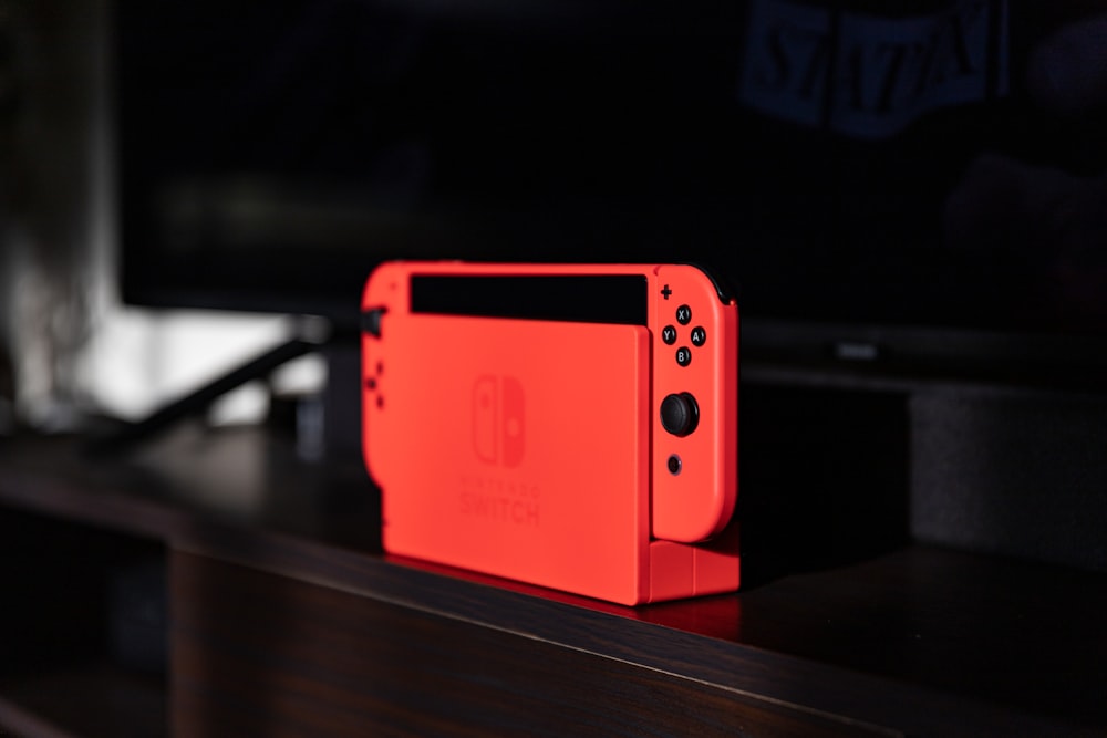 red nintendo switch on black table