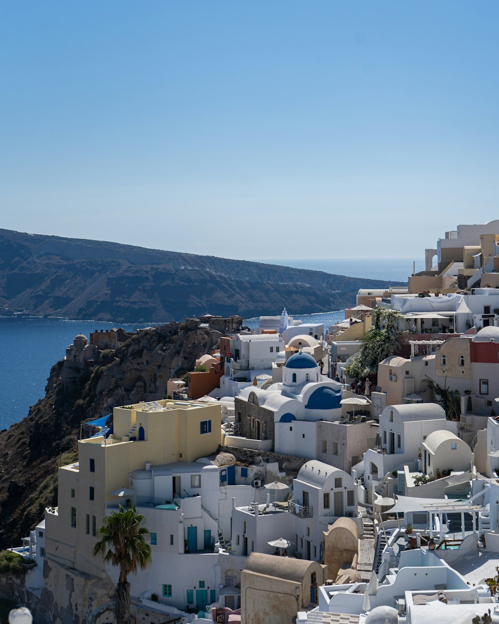 white and brown concrete houses near body of water during daytime