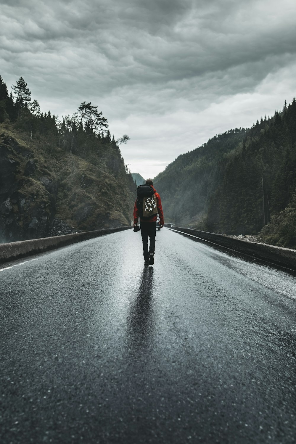 person in black jacket and black pants walking on road during daytime