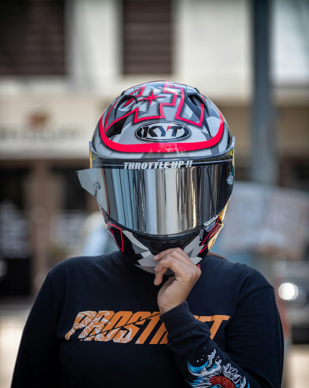 man in black and orange jacket wearing black and red helmet