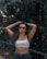 woman in white bikini top and black sunglasses standing beside green leaves during daytime