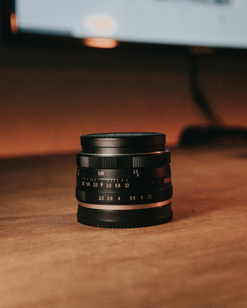 black camera lens on brown wooden table