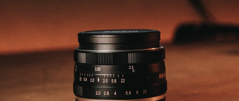 black camera lens on brown wooden table