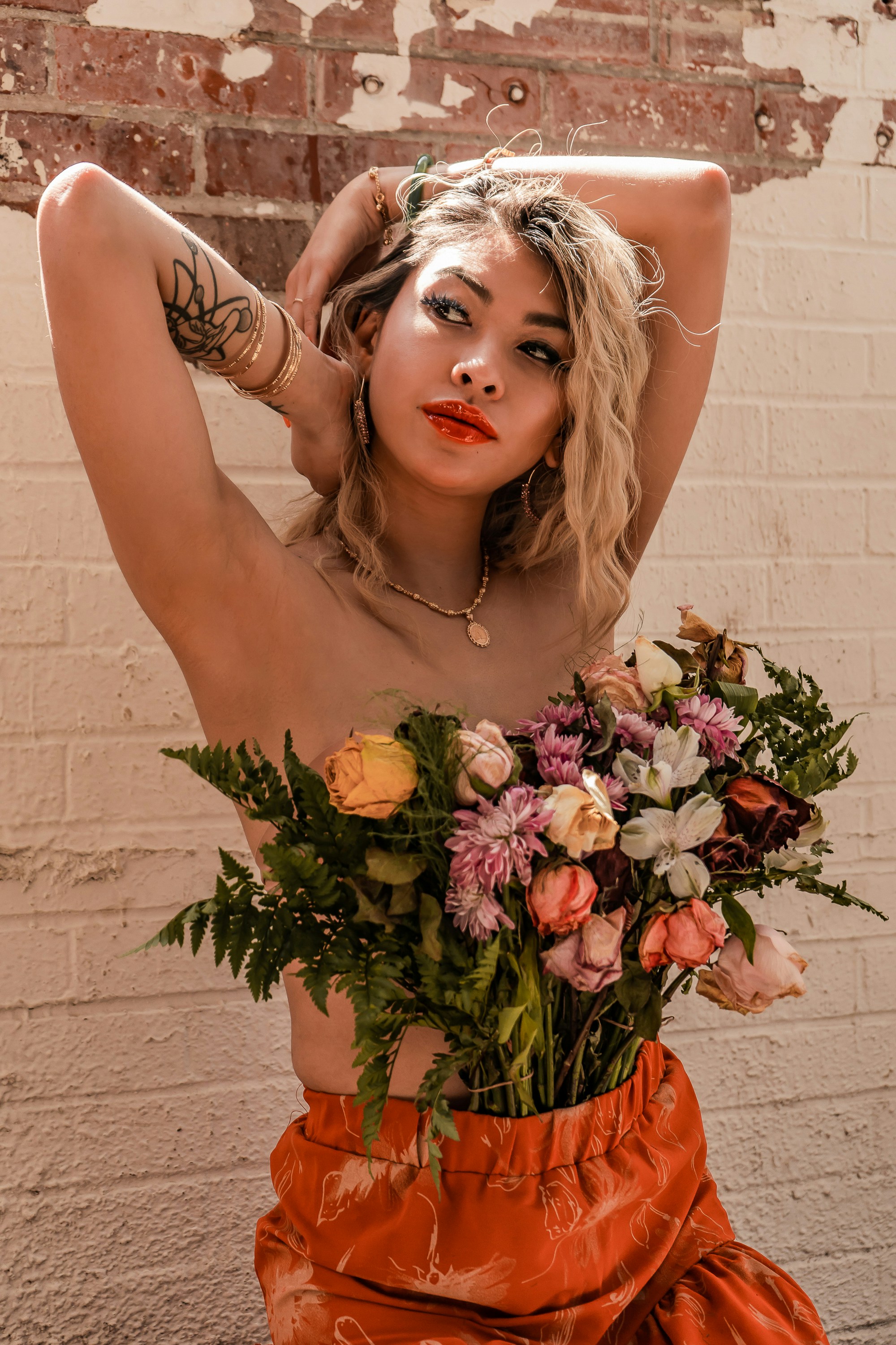 woman in white floral dress holding pink and white flowers