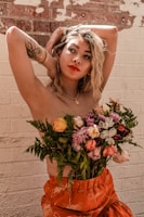 woman in white floral dress holding pink and white flowers