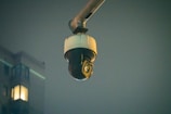High-definition CCTV camera mounted on a residential building exterior at dusk.