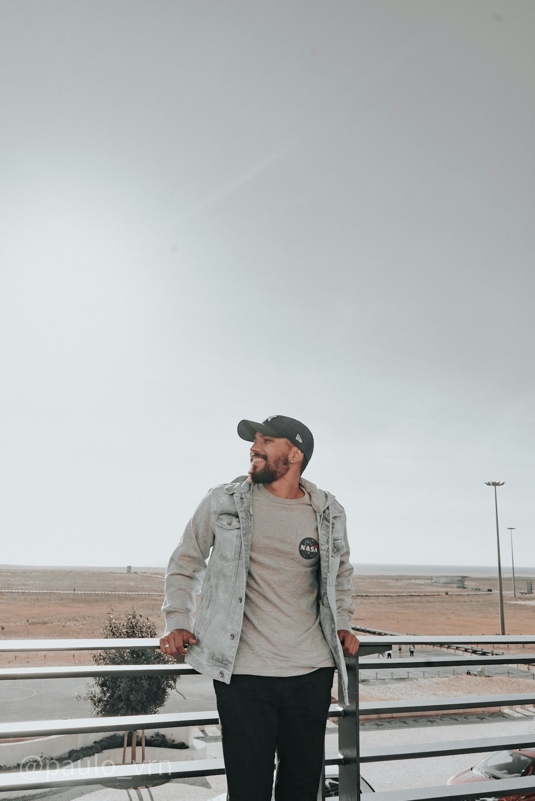 man in gray denim jacket standing on brown field during daytime