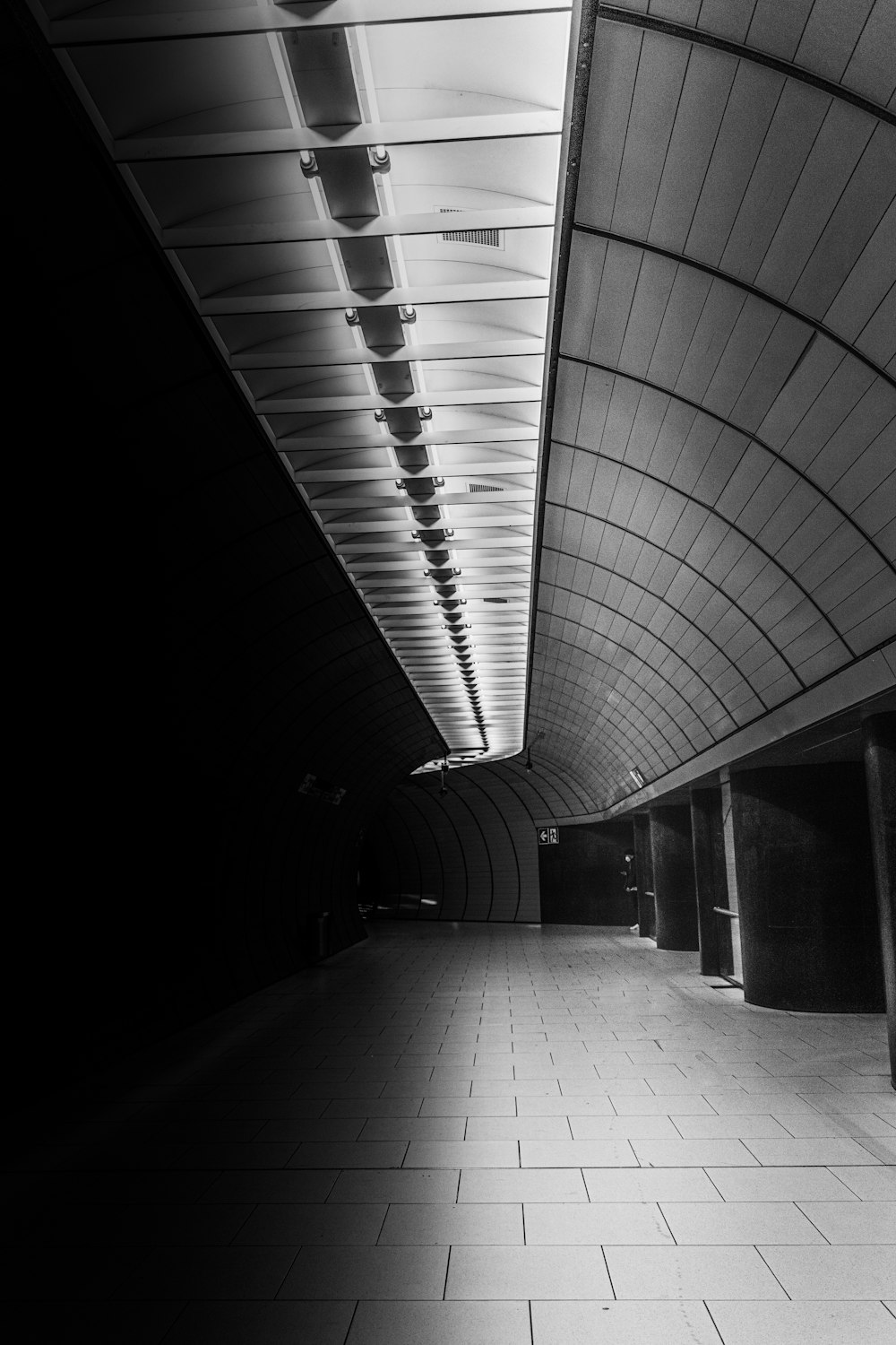 grayscale photo of tunnel with lights