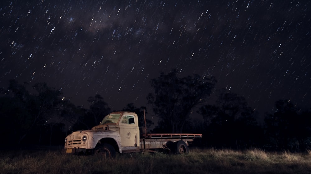 white single cab truck on green grass field during night time