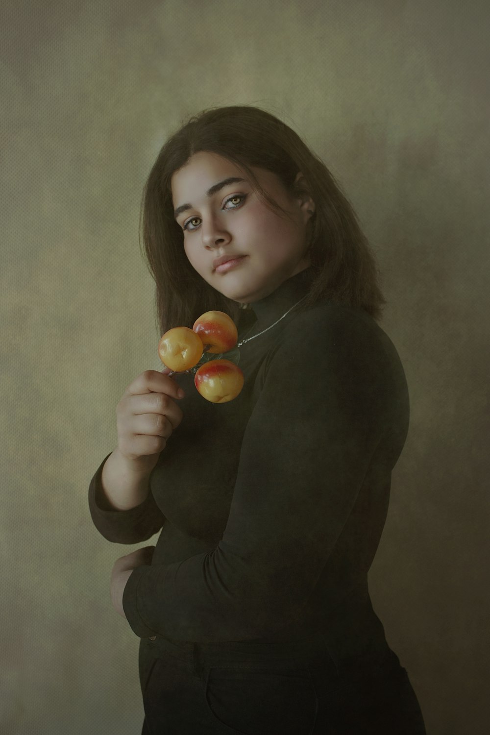 Mujer en camisa negra de manga larga sosteniendo fruta naranja