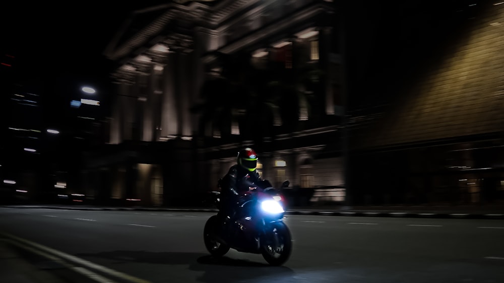 Mann fährt nachts Motorrad auf der Straße