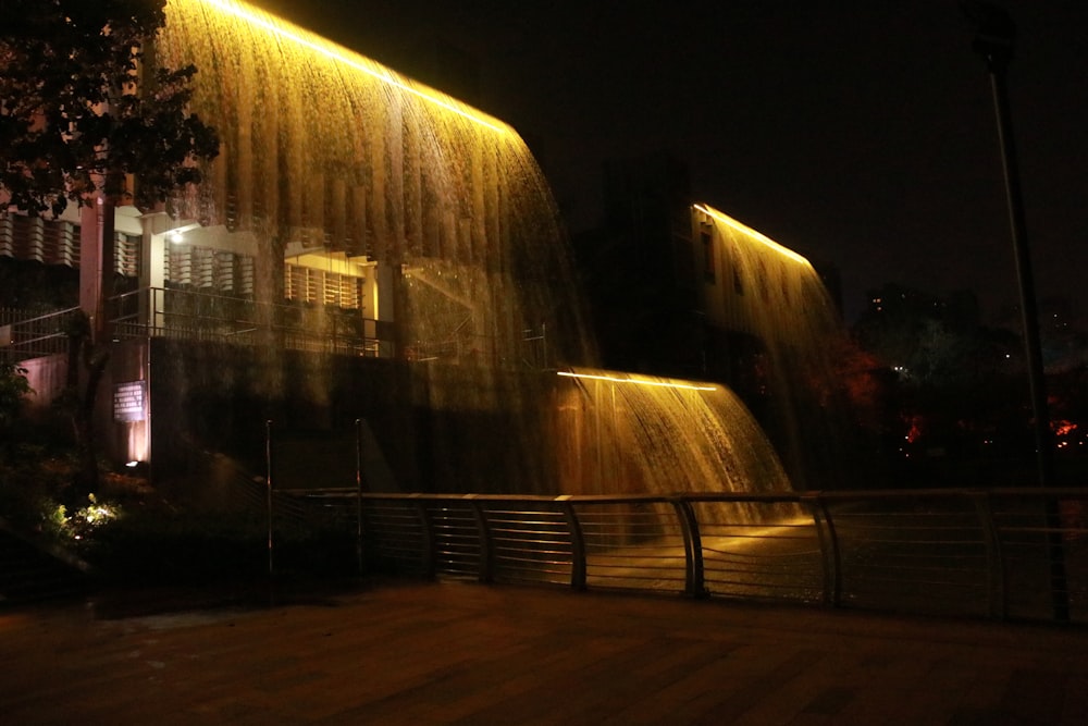 water fountain near white building during night time