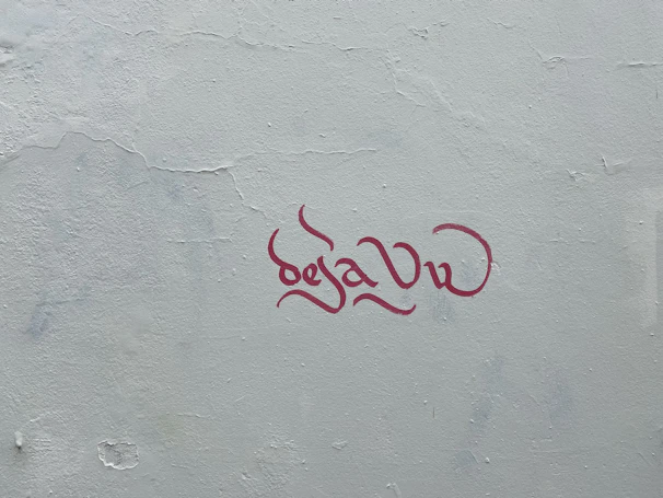 Close-up of bold, colorful lettering painted in energetic strokes on a textured wall.