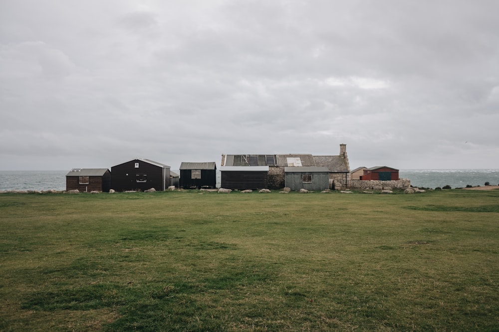 white and brown concrete house on green grass field under white clouds during daytime