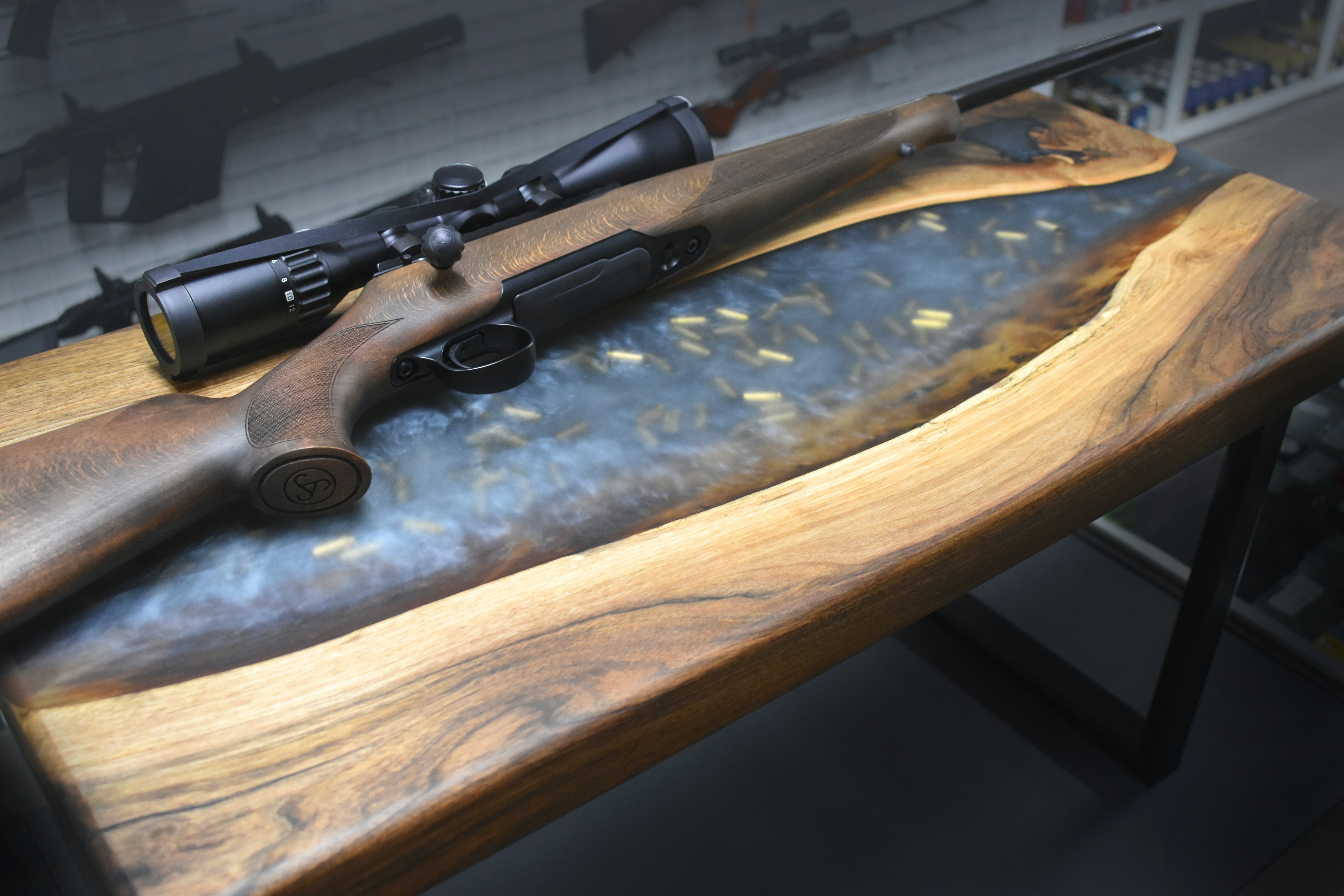 Rifle on wooden surface with ammunition rounds displayed nearby