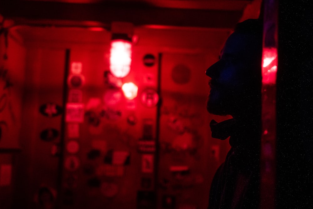 man in black jacket standing near red light