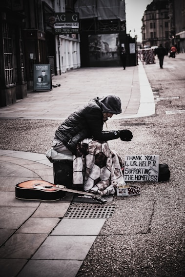 A volunteer warmly handing a winter coat to a grateful homeless veteran during a chilly morning.