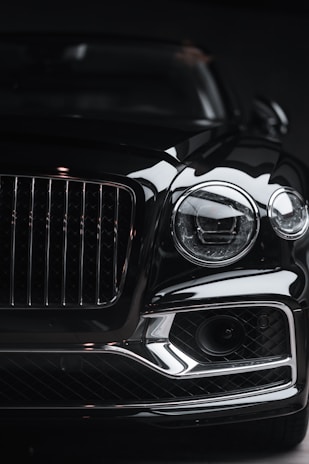 Front view of a luxury car with a bold red grille against a white background