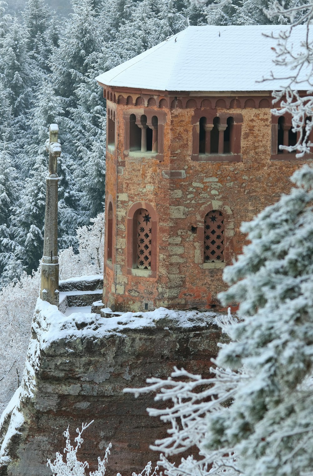 Edificio de hormigón marrón cubierto de nieve durante el día