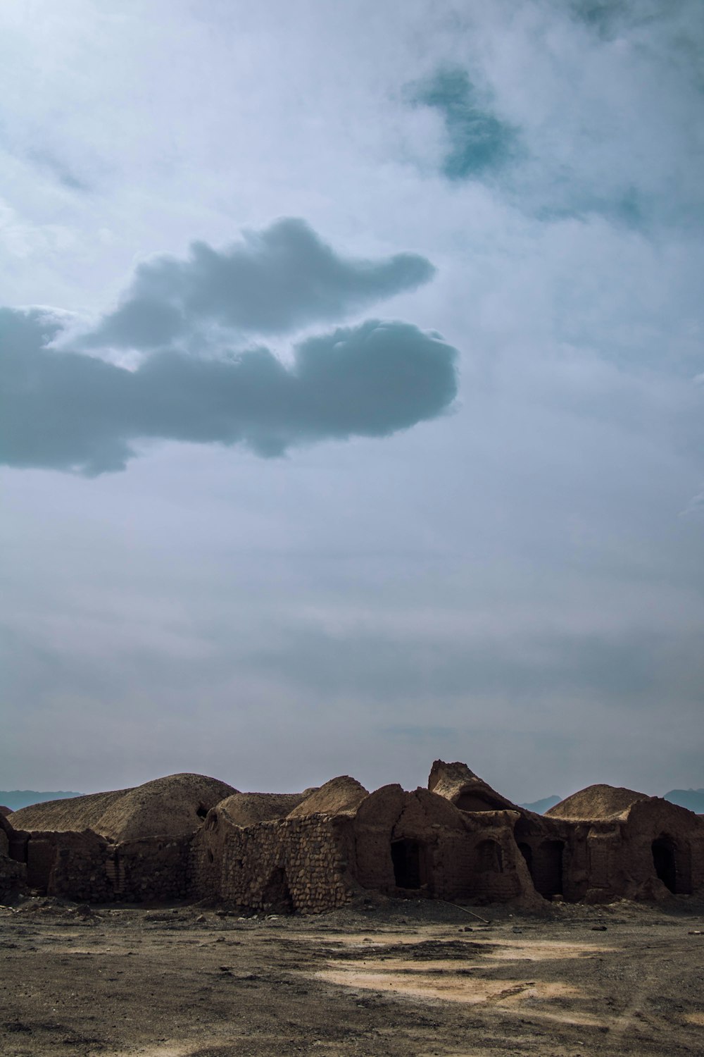 brown rocky mountain under white clouds and blue sky during daytime