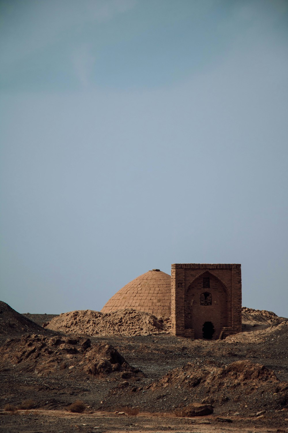 brown concrete building on brown sand under white sky during daytime