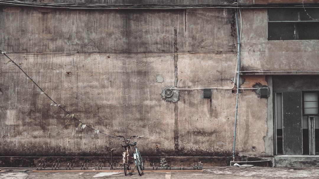 black bicycle parked beside brown wooden door