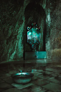 A serene meditation room bathed in glowing emerald and cyan light, with holographic patterns floating gently around.