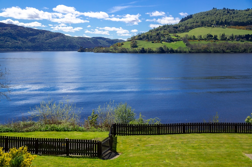 black wooden fence near lake during daytime